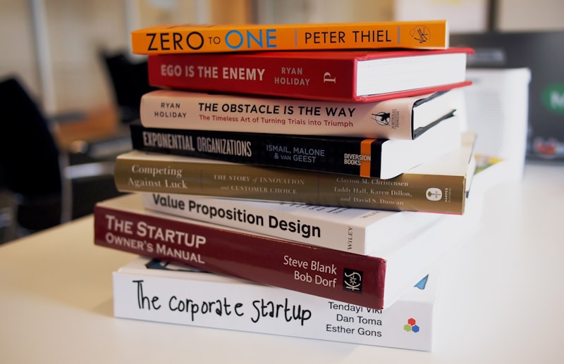 Stack of books with reading glasses, bookmark, and warm reading light